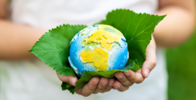 An image of a person holding a globe, representing sustainability over greenwashing.