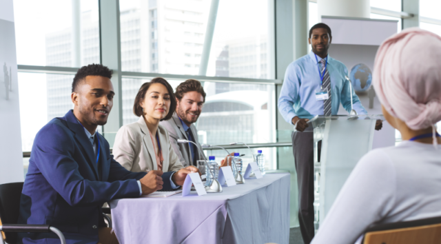 An image of marketing professionals gathering at a conference to learn more about market research trends.