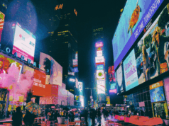 Branding Fatigue: Why Your Audience Is Tired of Your Message (and How to Fix It) A photo of Time Square at night, lit up with vibrant advertisements.