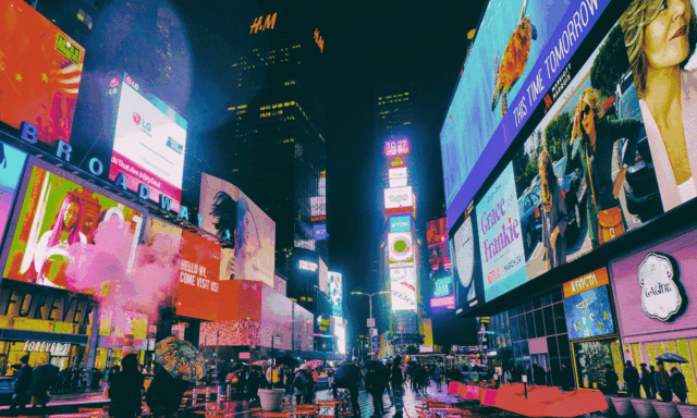 A photo of Time Square at night, lit up with vibrant advertisements.