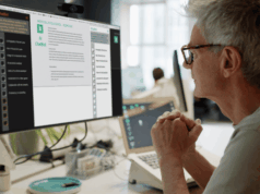 The AI Divide: How Marketers Really Feel About Automation A marketer sits at a desk reviewing AI-generated content on a computer screen in a modern office, reflecting the growing role of artificial intelligence in marketing workflows.