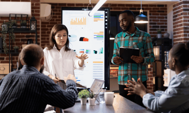 A marketing team reviews performance dashboards during a strategy meeting, analyzing data visualizations and discussing upcoming trends for 2026.