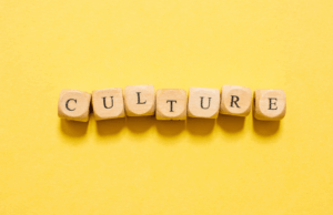 The Cultural Power of Branding: How Brands Influence Norms, Values, and Trust Letter blocks spelling out the word "culture" sit against a yellow background, emphasizing the cultural power of brands as the central theme of the piece.