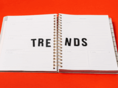How Marketers Can Bring Trends to Life With Pinterest Predicts An open planner on a bright red background with the word “TRENDS” spelled across its pages in black letters.