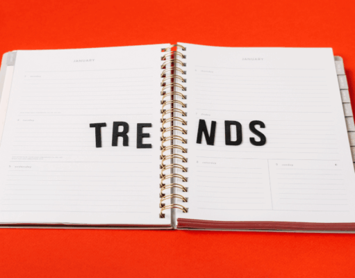 How Marketers Can Bring Trends to Life With Pinterest Predicts An open planner on a bright red background with the word “TRENDS” spelled across its pages in black letters.